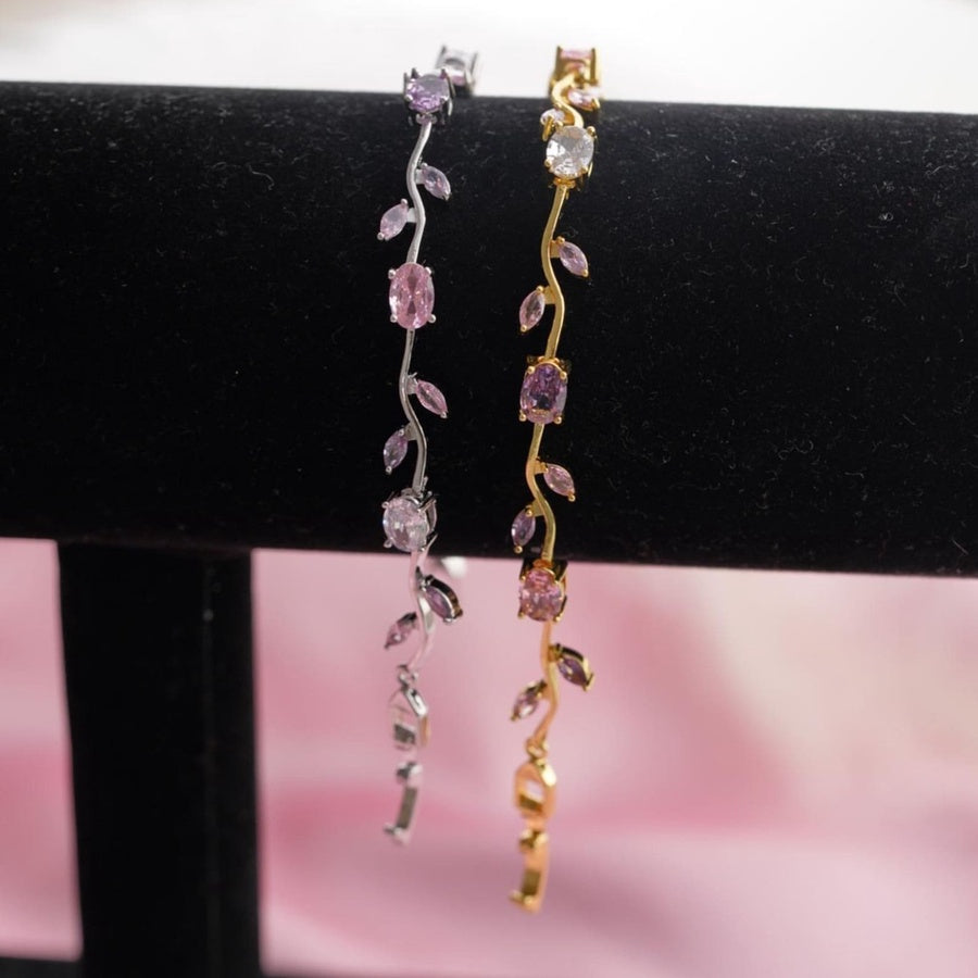 Gold bracelet with pink gemstones on a marble surface