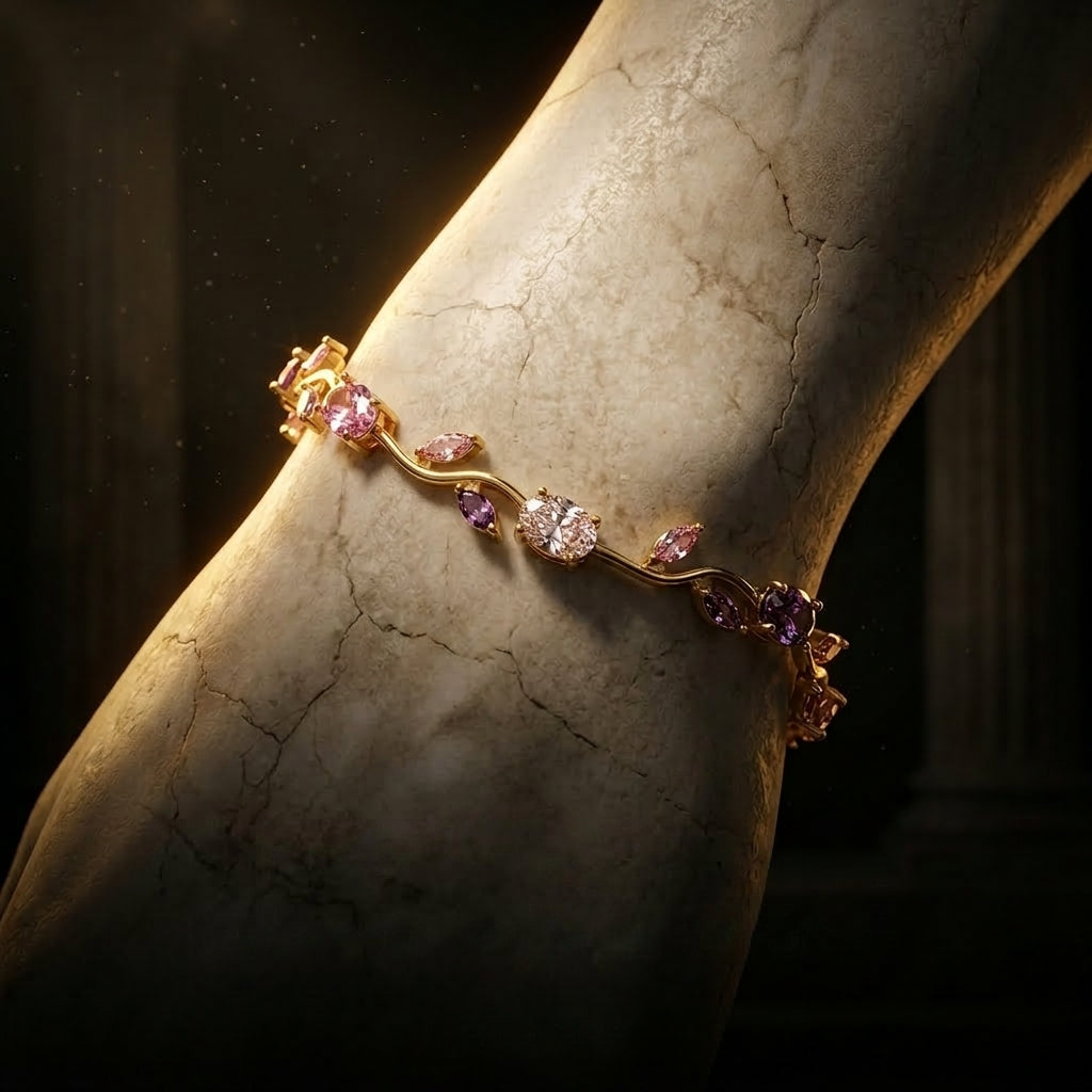 Gold bracelet with pink gemstones on a marble surface
