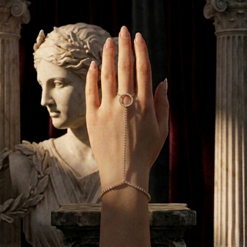 Hand wearing a ring with a classical statue in the background