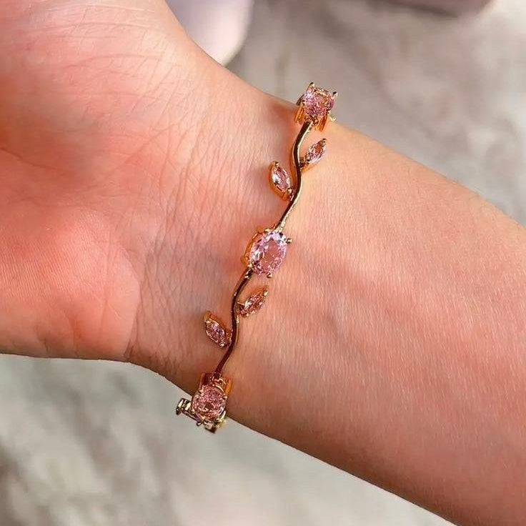 Bracelet with pink gemstones on a wrist against a neutral background